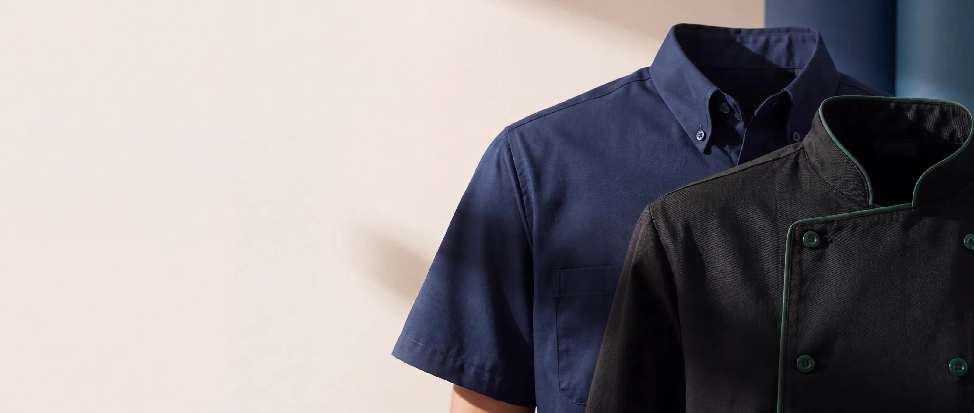 Camisa corporativa azul marino y filipina de chef negra con vivo verde, en primer plano